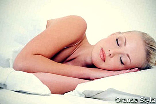Gyönyörű szőke nő alszik az ágyában