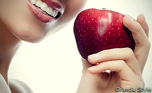 Lächelnde Frau, die roten Apfel hält