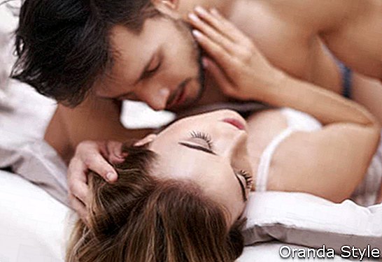 мъж целува жена на легло