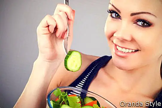 Pige spiser salat med friske grøntsager