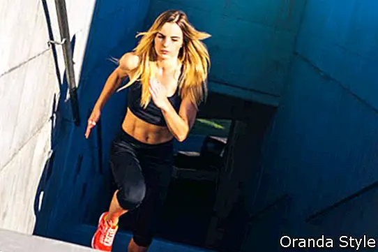 Athlète féminine courir rapidement dans les escaliers - entraînement d'escalier