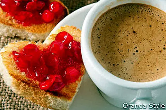 herzförmiger Toast mit Marmelade und einer Tasse Kaffee