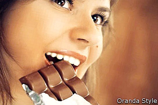 Frau beißt eine Tafel Schokolade