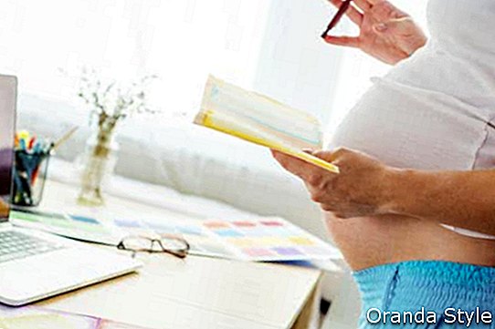 Nicht erkennbare schwangere Frau im Büro zu Hause mit Laptop