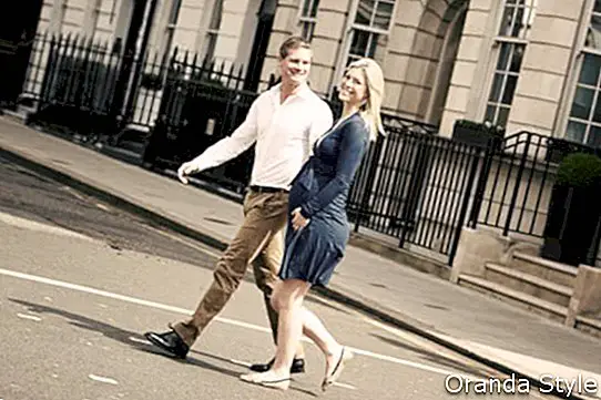 Par s nosečnico, ki prečka mestno cesto