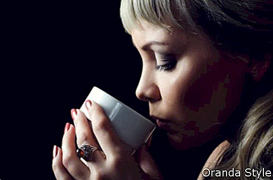Frauen-trinkender Kaffee in der Dunkelheit