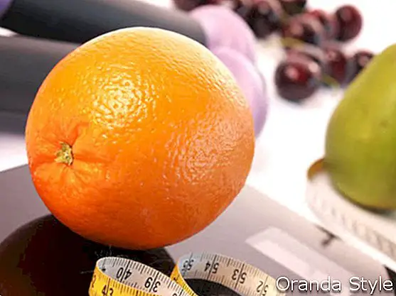 Orange auf einer Skala mit frischen Früchten