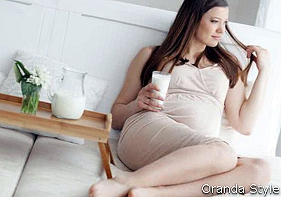 Hauptporträt der schwangeren Frau Glas Milch halten