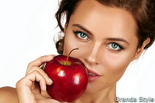 Fiatal nő gazdaság nagy piros alma, hogy élvezze az ízét