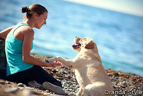 lány kutyájával a strandon