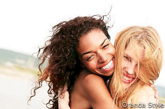két női barát átölelve és mosolyogva