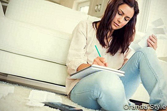 Nő a nappali szőnyegen számlák ellenőrzése