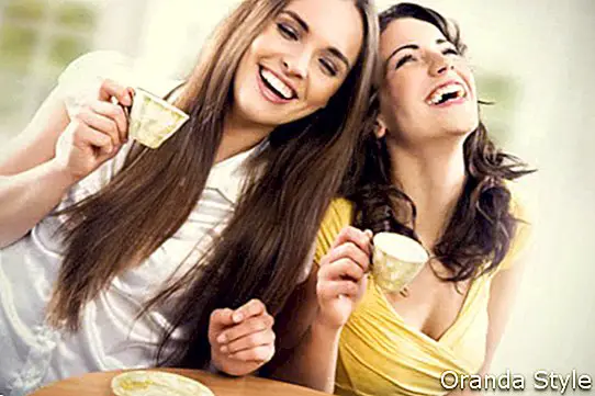 Két mosolygó lány van kávé idő