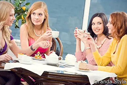 Vier junge Frauen sitzen am Tisch im Café