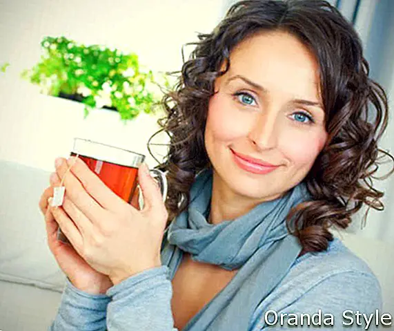 Лепа млада жена пије врући чај