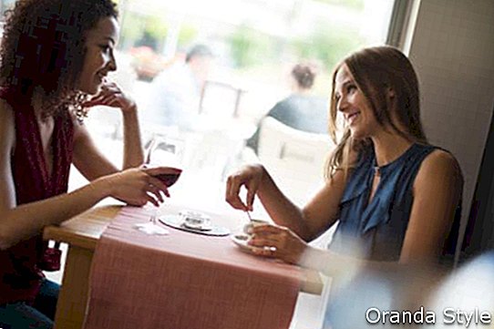 Csinos nők beszélgetni és szórakozni a kávézóban