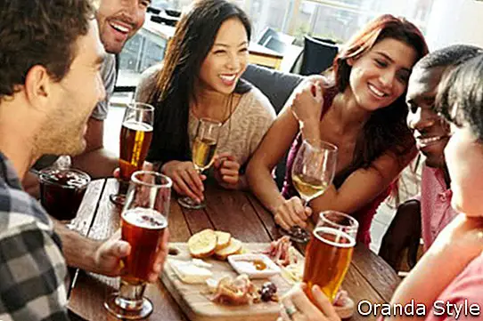 Gruppe Freunde, die Getränk und Snack in Dachspitzen-Bar 2 genießen