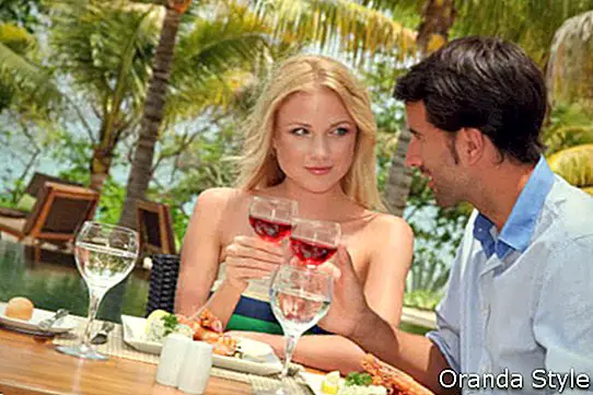 คู่รักหนุ่มสาวกำลังเพลิดเพลินกับอาหารกลางวันในร้านอาหารของรีสอร์ท