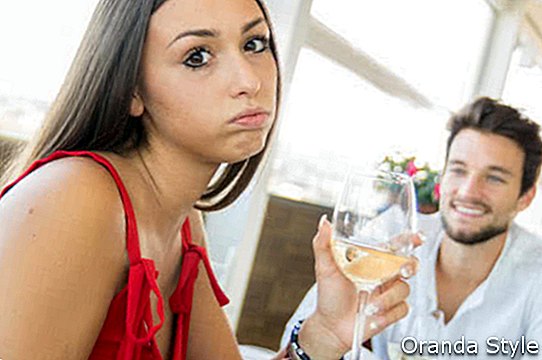 Junge Frau, die im Restaurant eine gereizte Ausdrucksgeste auf ein schlechtes Datum macht