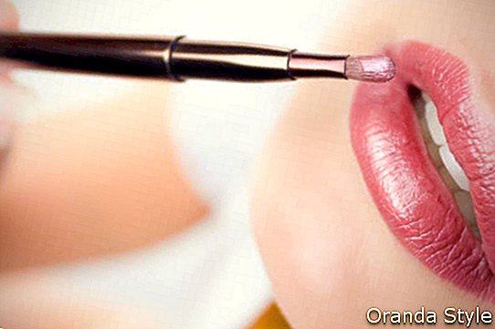 weibliche Lippen und ein Pinsel mit Lippenstift