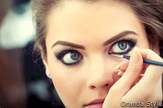 Artis make-up menggunakan celak mata cecair dengan berus