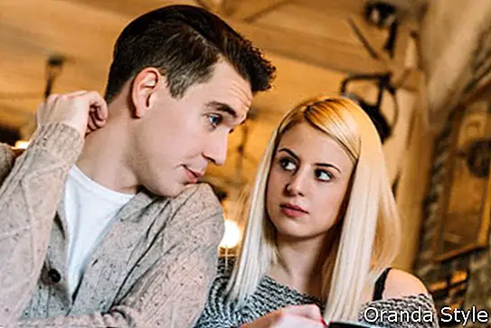 Zwei junge Erwachsene in einem Café, das einige Entscheidungen trifft
