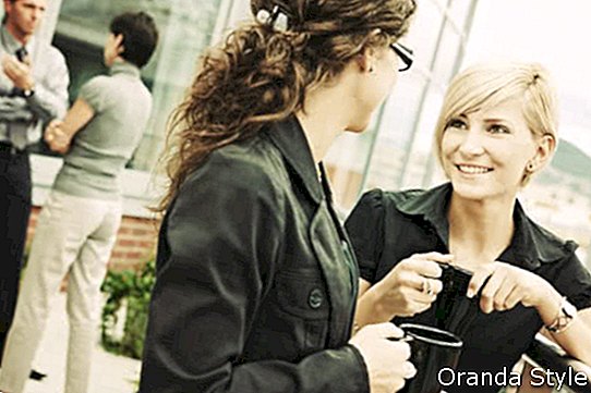 Geschäftsfrauen, die Pause auf der trinkenden Kaffeeunterhaltung der Büroterrasse im Freien haben