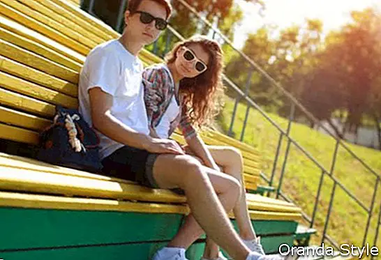 Влітку молода сучасна стильна пара в сонцезахисні окуляри відпочиває в місті