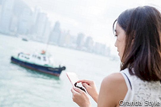 Жена која користи мобител у граду Хонг Конгу