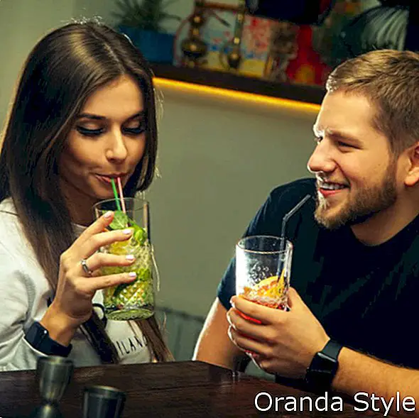 атрактивна двойка флиртува и пие коктейли в бара