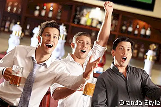 Junge Leute mit Bier schauen Fußball in einer Bar