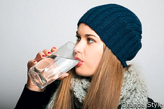 Wintermädchen, das ein Glas Wasser trinkt