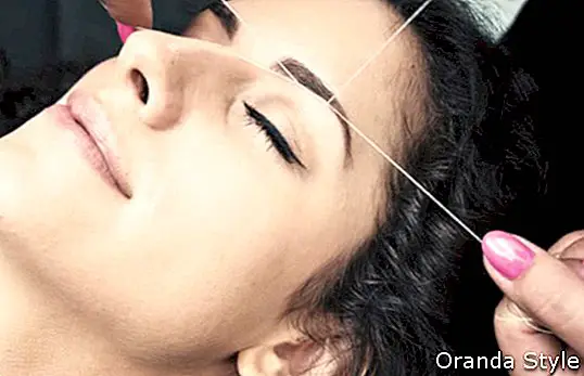 Frau im Beauty-Salon auf Gesichtsbehaarung Augenbrauen Threading-Verfahren