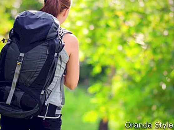 молода жінка з рюкзаком у лісі