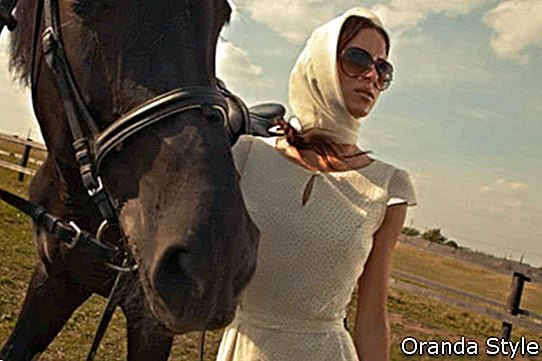 лепа девојка у белој хаљини са коњем на природи