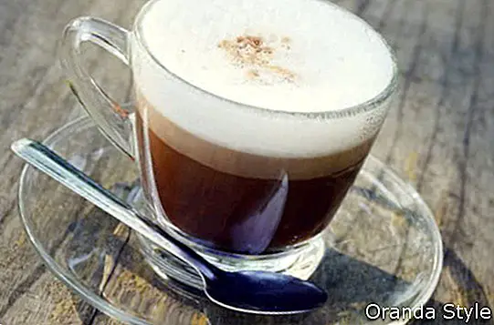 latte kávé egy pohárban a régi fából készült asztal