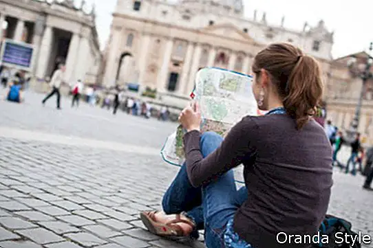 csinos, fiatal női turista tanulmányozza a térképet, a st. peters téren
