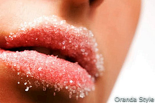 Les lèvres rouges de la femme parsemées de sucre