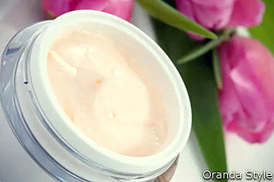 tarro de crema hidratante para la cara rodeada de flores de tulipán rosa