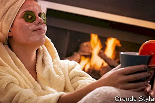 Kvinde i badekåbe og håndklæde slapper af i ansigtsmaske
