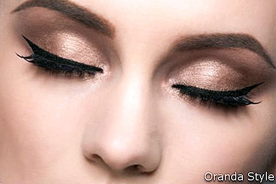 vrouw-face-with-gold-oogschaduw-and-gevleugelde eyeliner