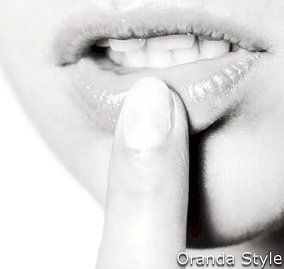 Macro de joven modelo tocando los labios con el dedo