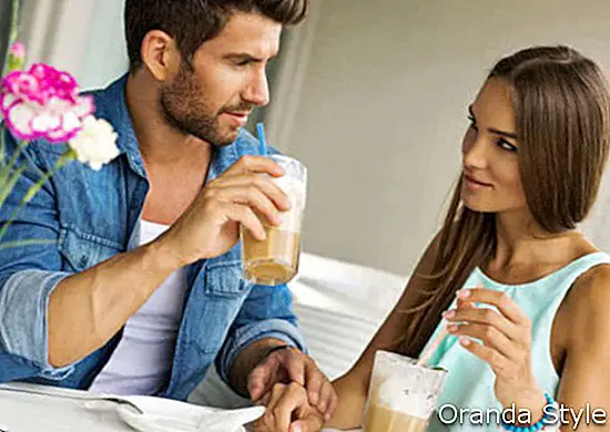 Ungt par som snakker og drikker kaffe