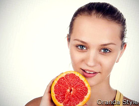 Счастливая девушка с грейпфрутом в руке