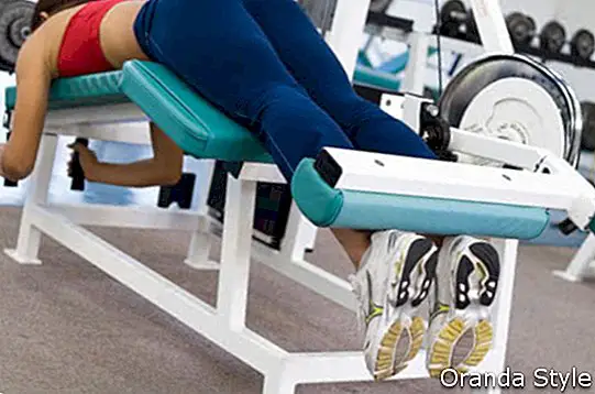 Eine Frau liegt auf einer Achillessehnenmaschine in einem Fitnessstudio