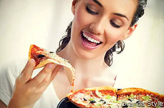 Lächelndes Mädchen, das Pizza isst