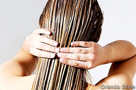 Žena použití kondicionér vlasů