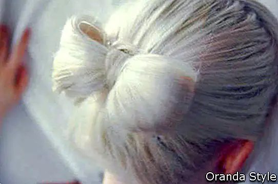 femeie blondă care are părul în arc