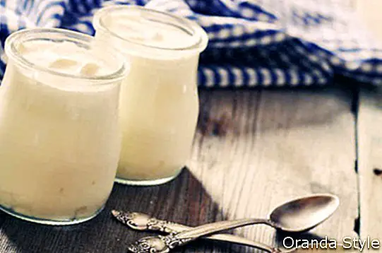 Yogur griego en frascos de vidrio con cucharas