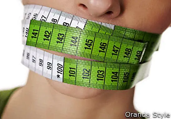 mladá žena se zeleným měřicí pásky pokrývající ústa